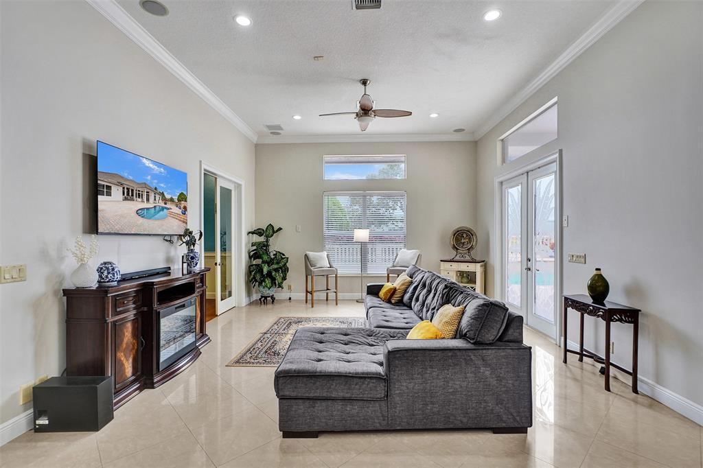 8426 Sawpine Road Delray Beach, FL 33446 - Photo 34 of 91 a living room with furniture a large window and a flat screen tv