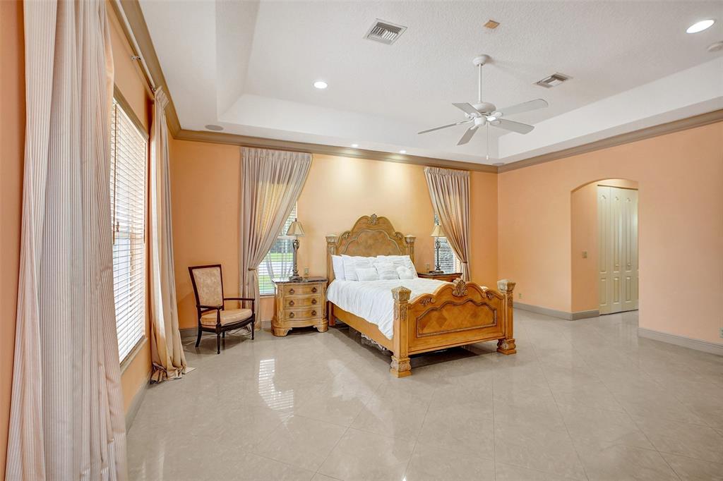 8426 Sawpine Road Delray Beach, FL 33446 - Photo 77 of 91 a spacious bedroom with a bed and a chandelier