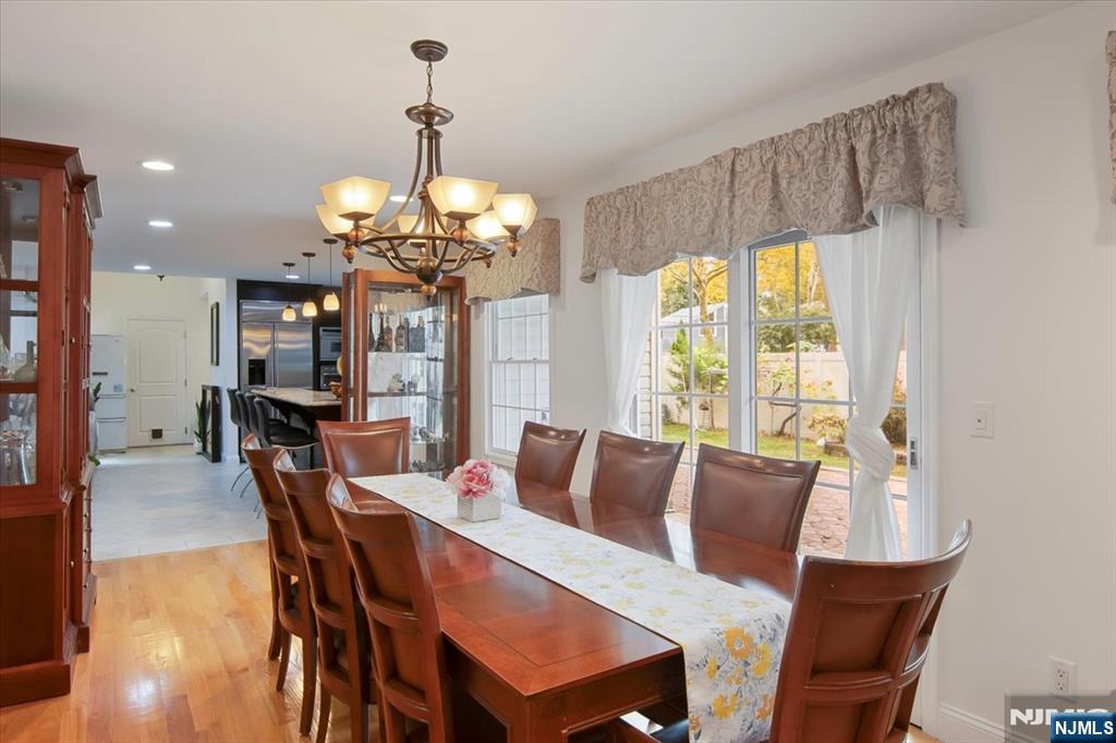 85 Harvey Avenue Paramus, NJ 07652 - Photo 11 of 32 a dining room with wooden floor a chandelier a wooden table and chairs