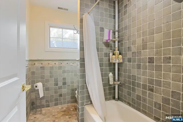 a large bed sitting in a bedroom next to a window with pc on the dresser