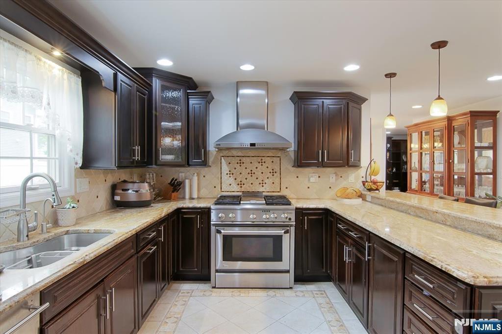 85 Harvey Avenue Paramus, NJ 07652 - Photo 8 of 32 a kitchen with stainless steel appliances granite countertop a sink a stove and a refrigerator