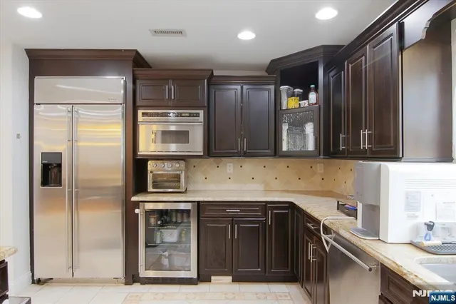 a kitchen with stainless steel appliances granite countertop a refrigerator and a sink