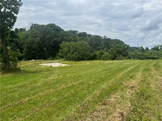 a view of a green field with wooden fence