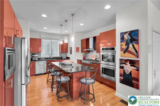 a kitchen with stainless steel appliances granite countertop a sink a window and a counter space