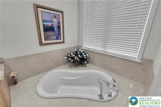 a bathroom with a granite countertop sink a mirror and a bathtub