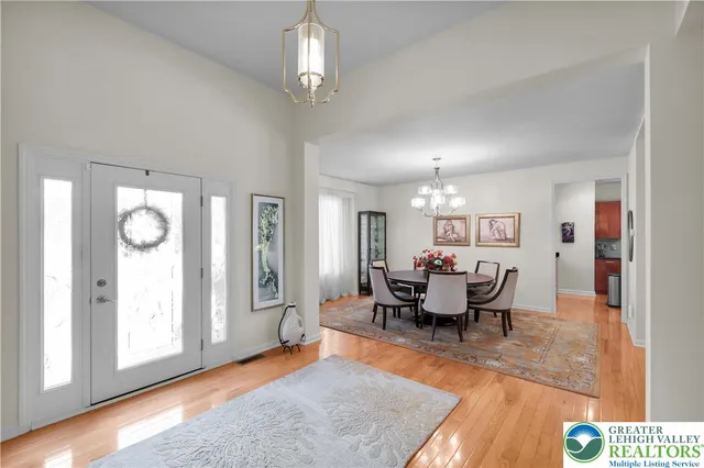 a living room with furniture a chandelier and a mirror