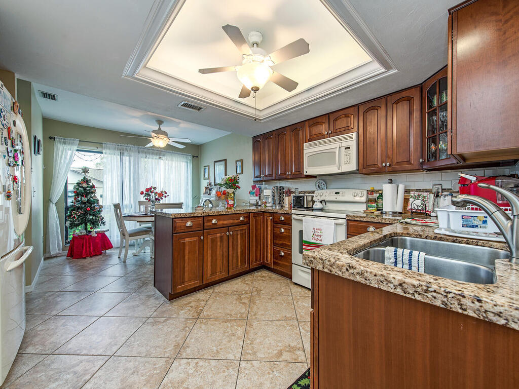 205 Deerwood Circle Naples, FL 34113 - Photo 5 of 12 a kitchen with a sink a stove and cabinets