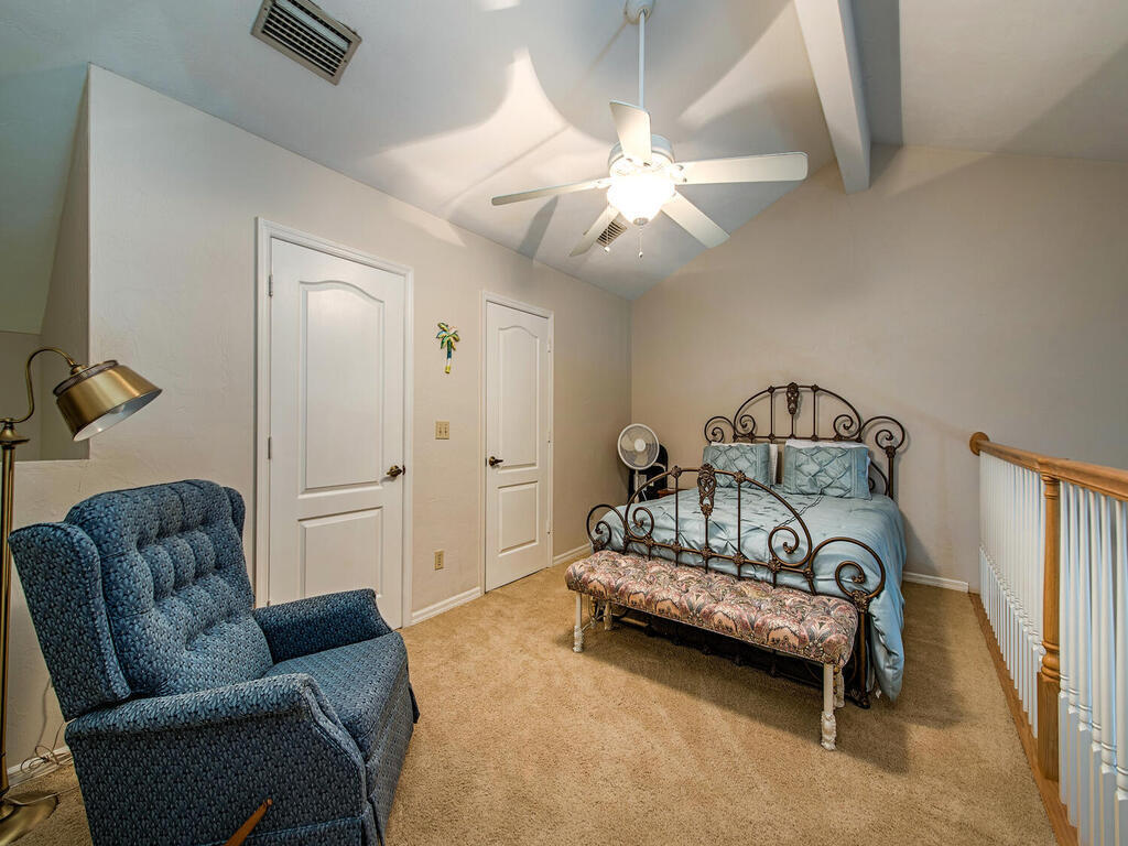 205 Deerwood Circle Naples, FL 34113 - Photo 6 of 12 a bedroom with furniture and a chandelier