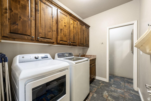 7776 Wagon Road East St. George, UT 84770 - Photo 18 of 76 Laundry room with stone finish floors, washer and clothes dryer, and cabinet space