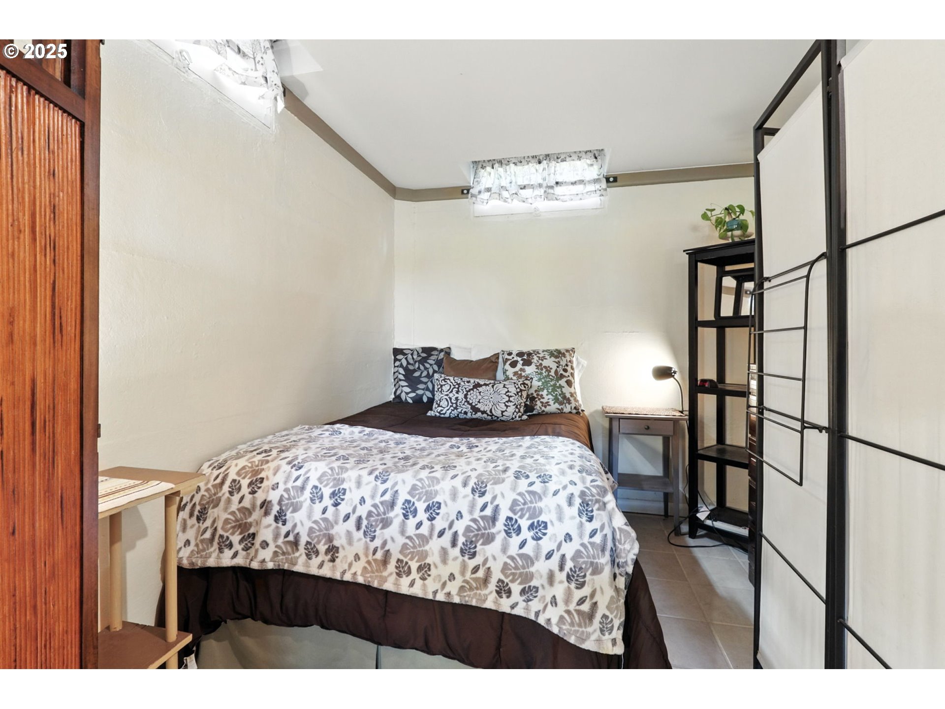 7149 Southwest 3rd Avenue Portland, OR 97219 - Photo 25 of 42 a bedroom with a bed and a chandelier