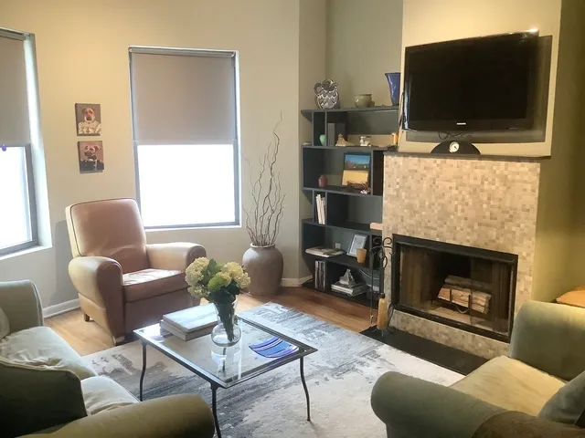 a living room with furniture a flat screen tv and a fireplace
