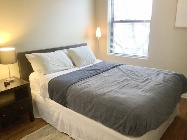 5216 North Kenmore Avenue, Unit 3S Chicago, IL 60640 - Photo 8 of 16 a bed sitting in a bedroom next to a window