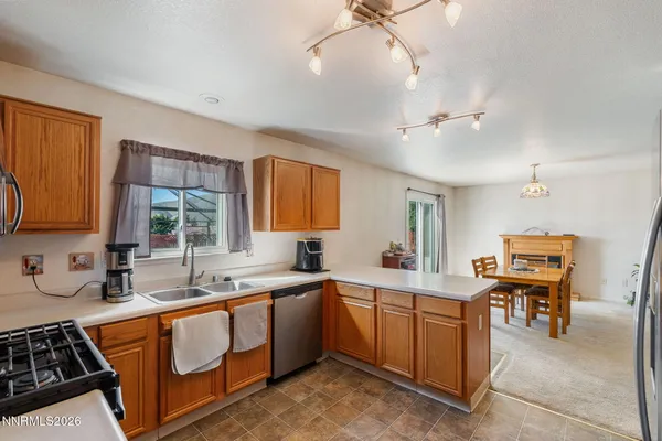 a kitchen that has a sink a stove and chairs