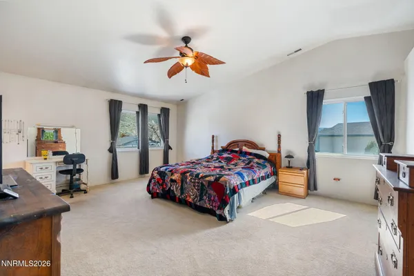 a bedroom with a bed and a flat tv screen on dresser