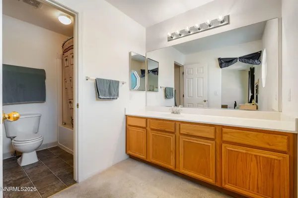 a spacious bathroom with a toilet sink and mirror