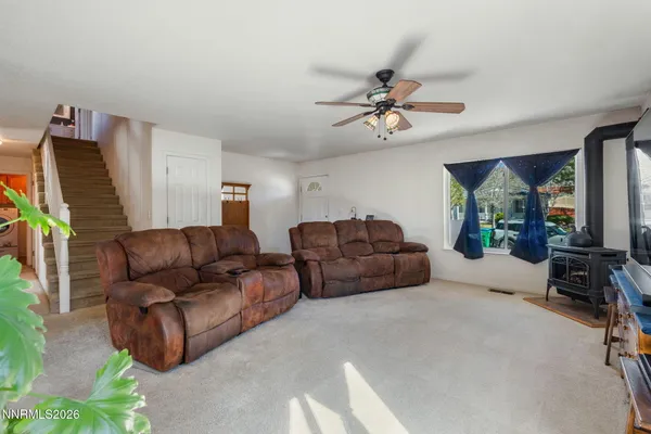 a living room with furniture a ceiling fan and a rug