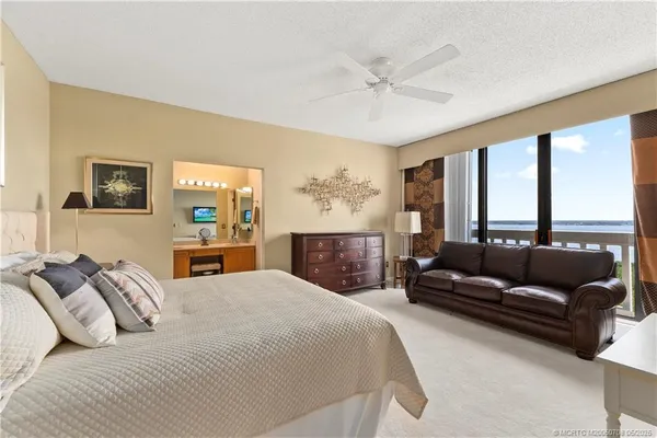 a bedroom with a large bed couch and a window