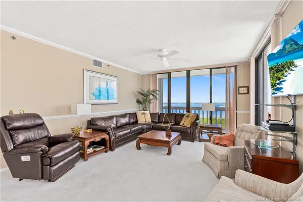 a living room with furniture and floor to ceiling windows