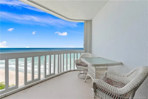 a balcony with a table and chairs
