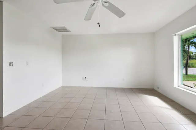 a view of a big room with wooden floor and windows