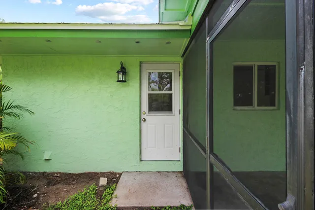 a view of a house with a yard and potted plants