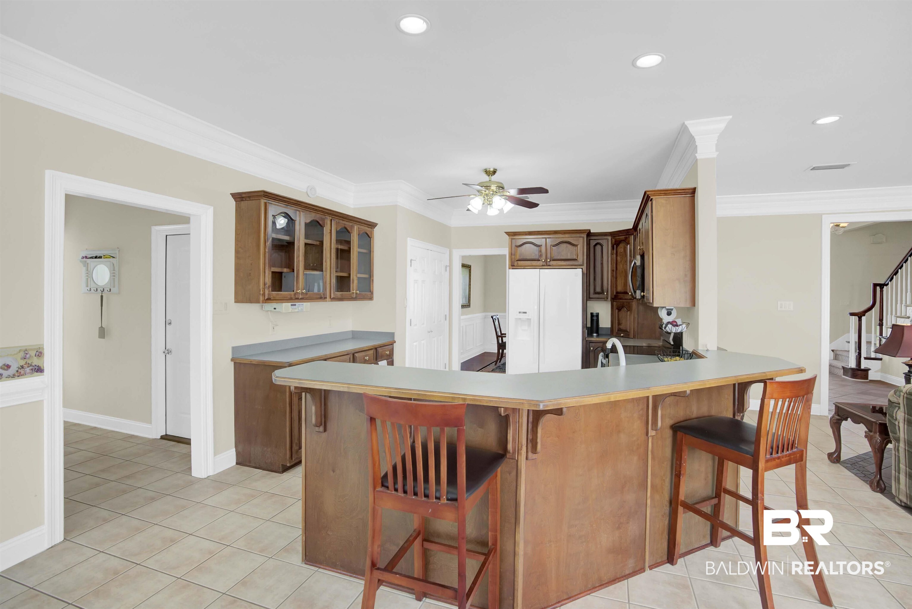 27688 Rigsby Road Daphne, AL 36526 - Photo 20 of 56 Kitchen featuring light tile patterned floors, white refrigerator with ice dispenser, a kitchen bar, ceiling fan, and kitchen peninsula