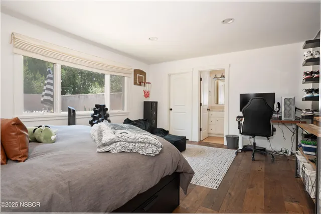 a bedroom with a bed and large windows