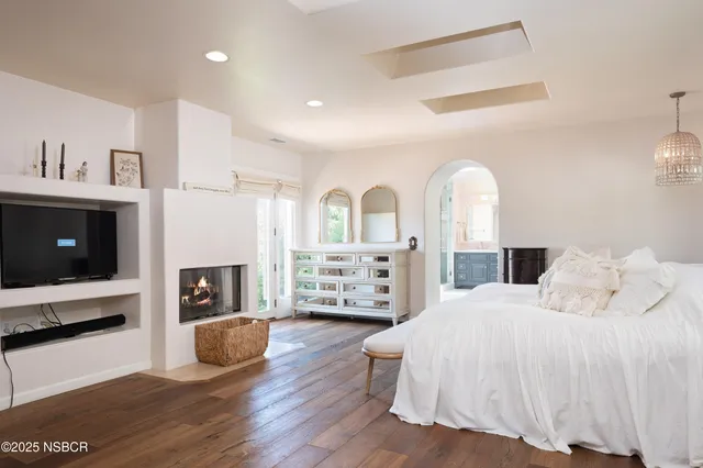 a spacious bedroom with a balcony a bed and a television