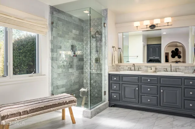 a bathroom with a double vanity sink mirror and shower