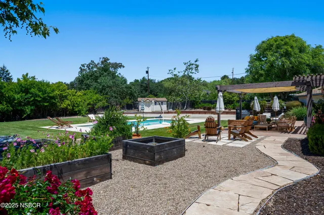 a view of a patio with furniture and a garden
