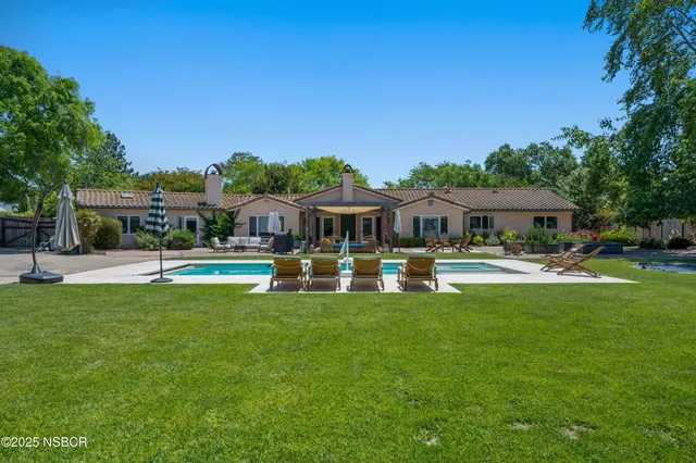 a front view of a house with swimming pool having outdoor seating