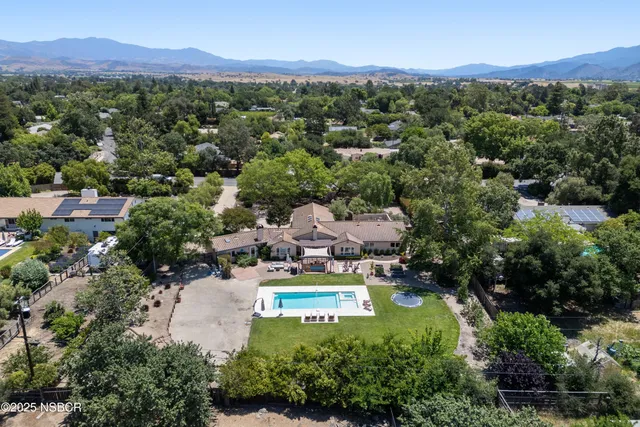an aerial view of residential houses with outdoor space and street view