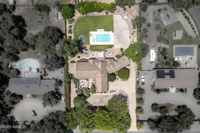 an aerial view of a house with a yard and lake view