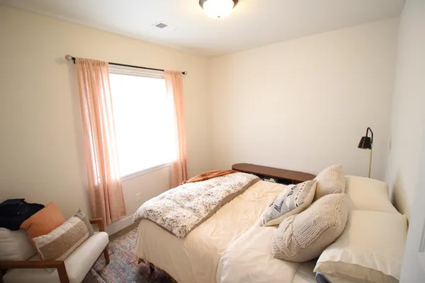 a bedroom with a bed and a chair