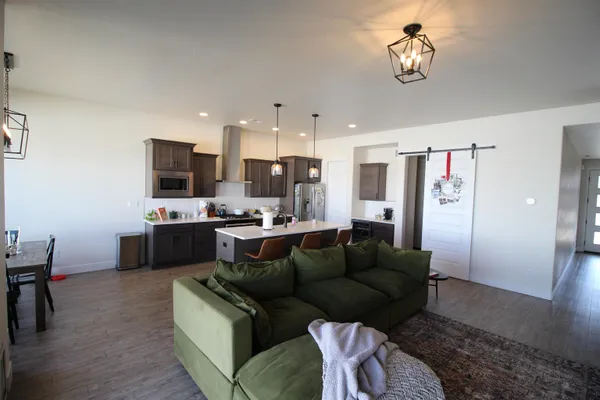 a living room with stainless steel appliances kitchen island granite countertop furniture and a view of kitchen