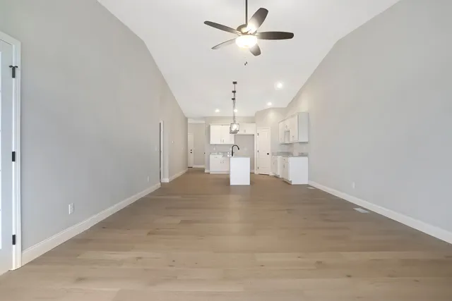 a view of an empty room and kitchen view