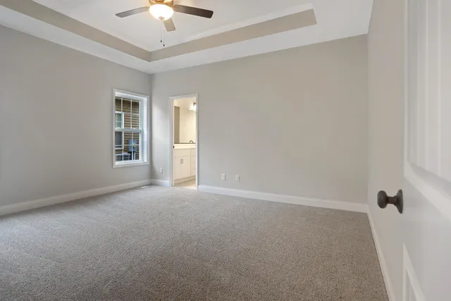 an empty room with a ceiling fan and a window