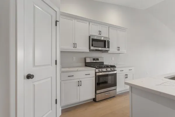 a kitchen with white cabinets and stainless steel appliances