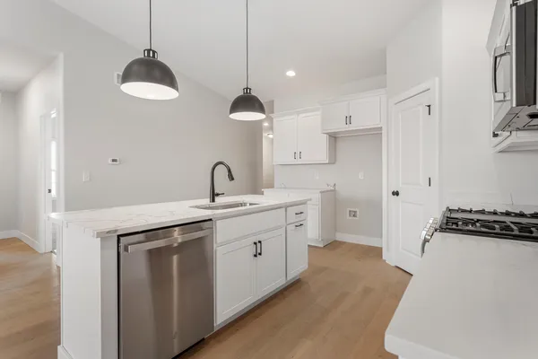 a kitchen with a sink stainless steel appliances a counter space and a window