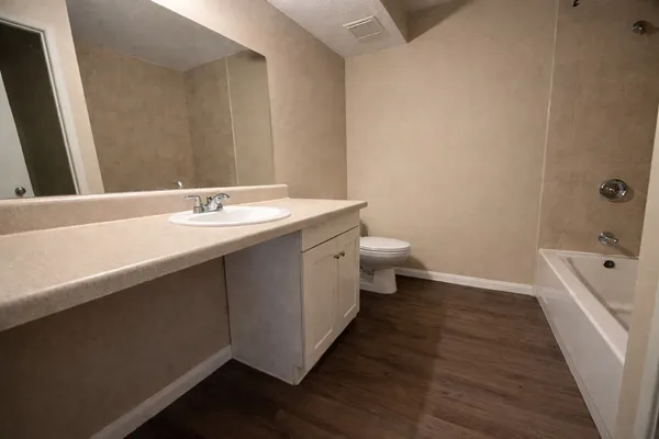 a bathroom with a granite countertop sink a toilet and bathtub
