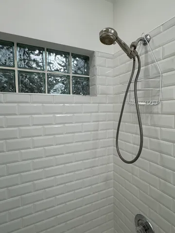 a bathroom with a double vanity sink a toilet a mirror and shower