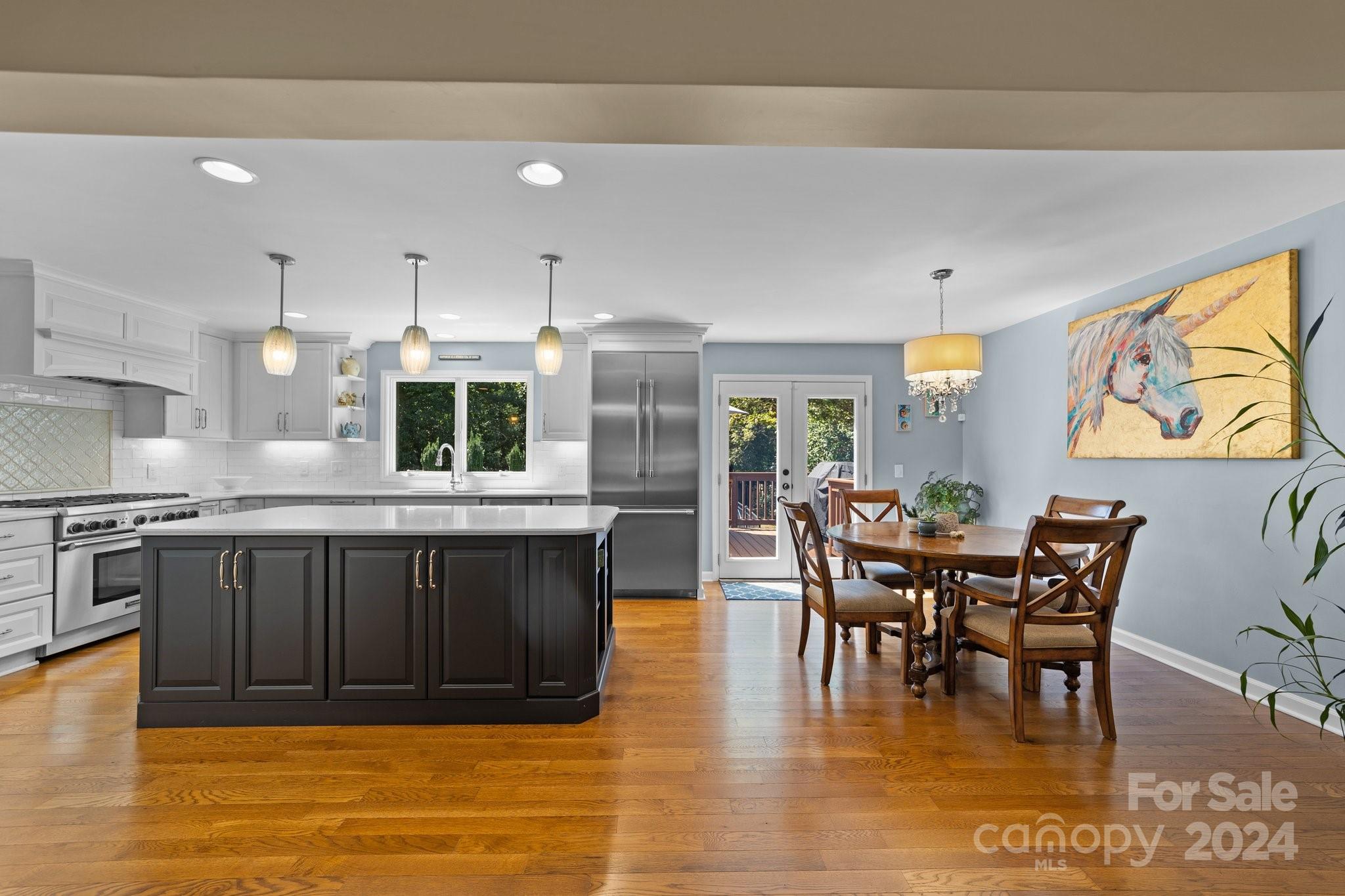 1060 Churchill Road Davidson, NC 28036 - Photo 19 of 41 a kitchen with stainless steel appliances wooden cabinets dining table and chairs