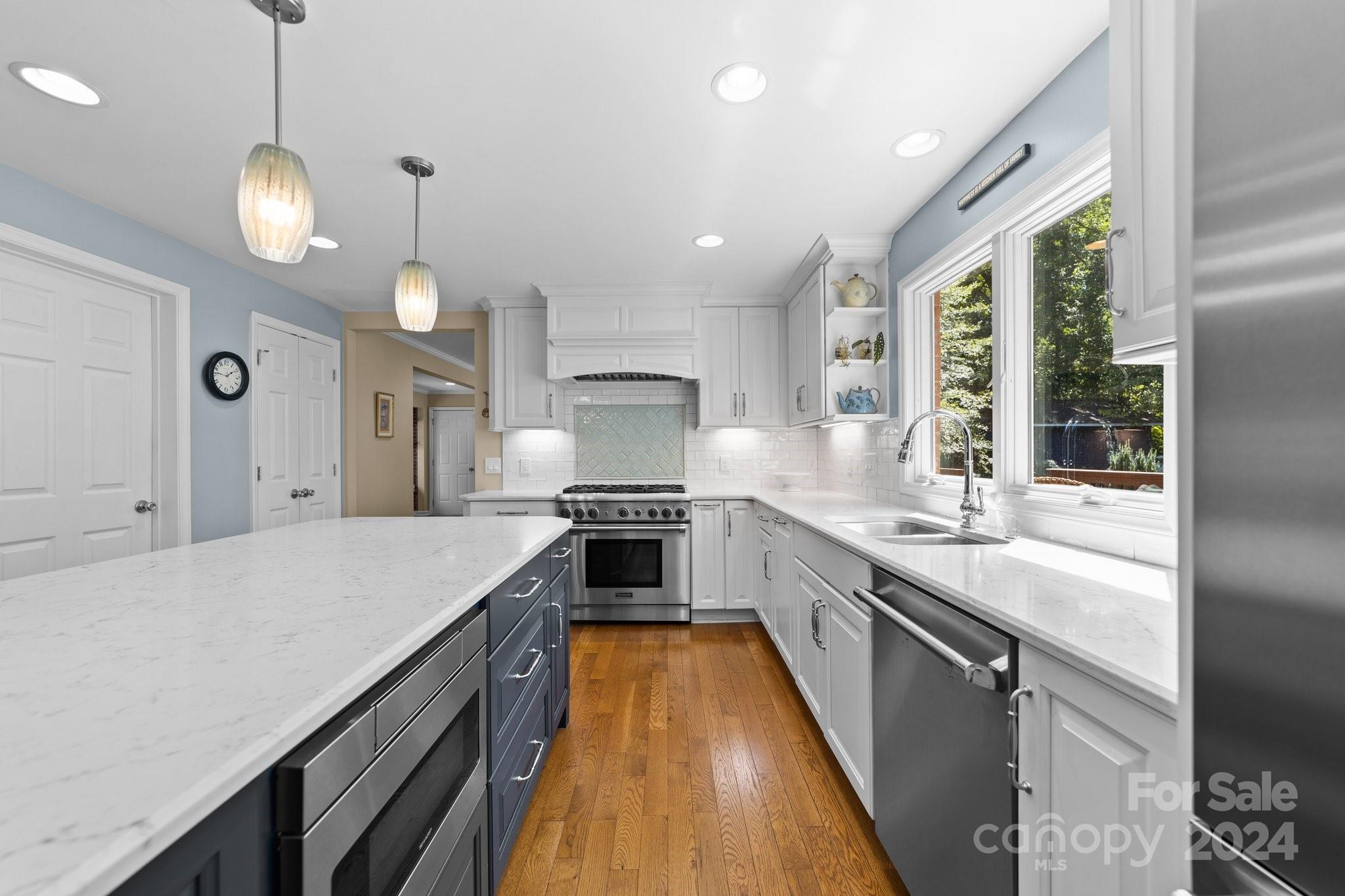1060 Churchill Road Davidson, NC 28036 - Photo 25 of 41 a large kitchen with kitchen island a large counter space a sink appliances and a large window
