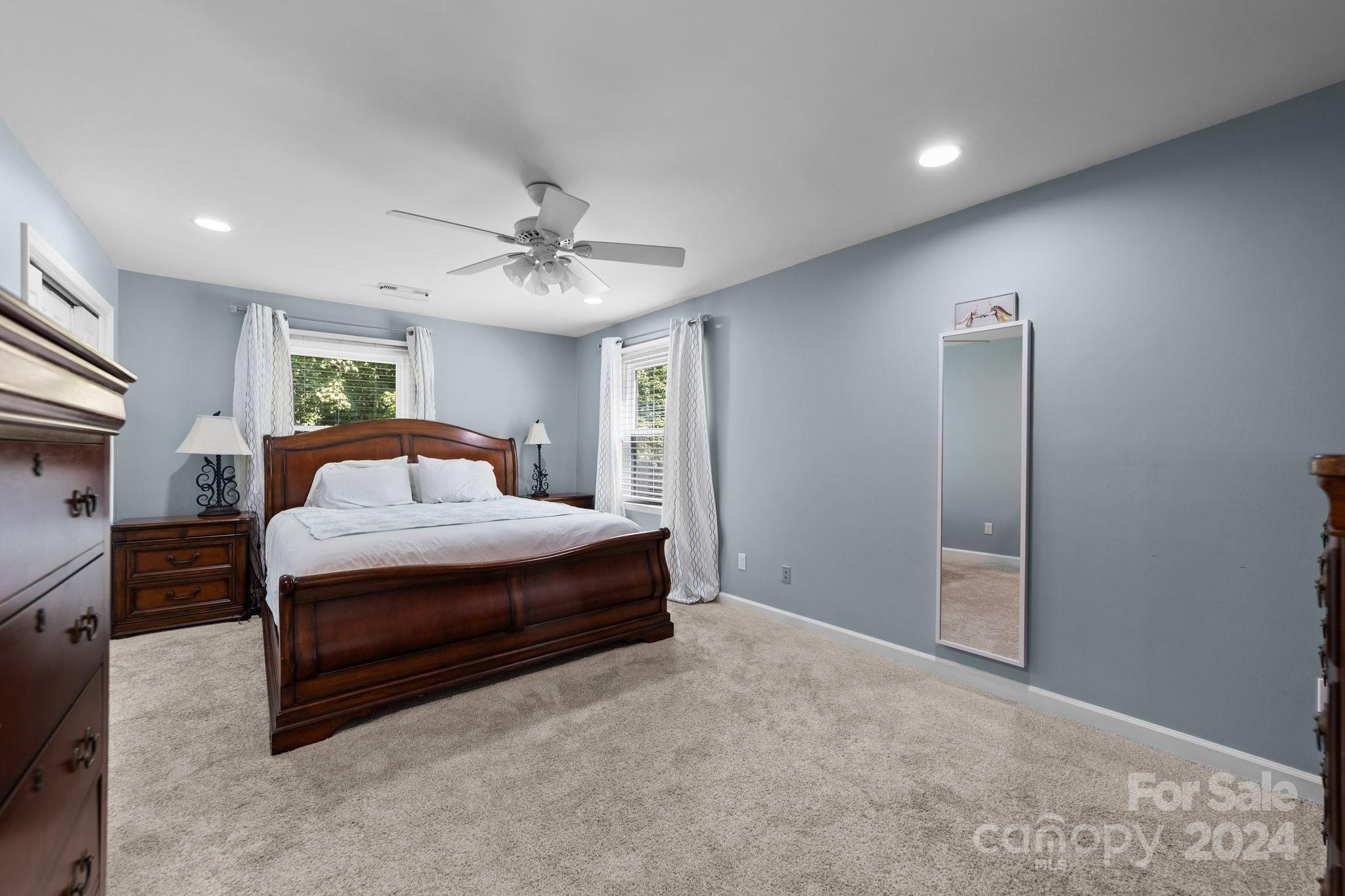 1060 Churchill Road Davidson, NC 28036 - Photo 29 of 41 a spacious bedroom with a bed and a chandelier