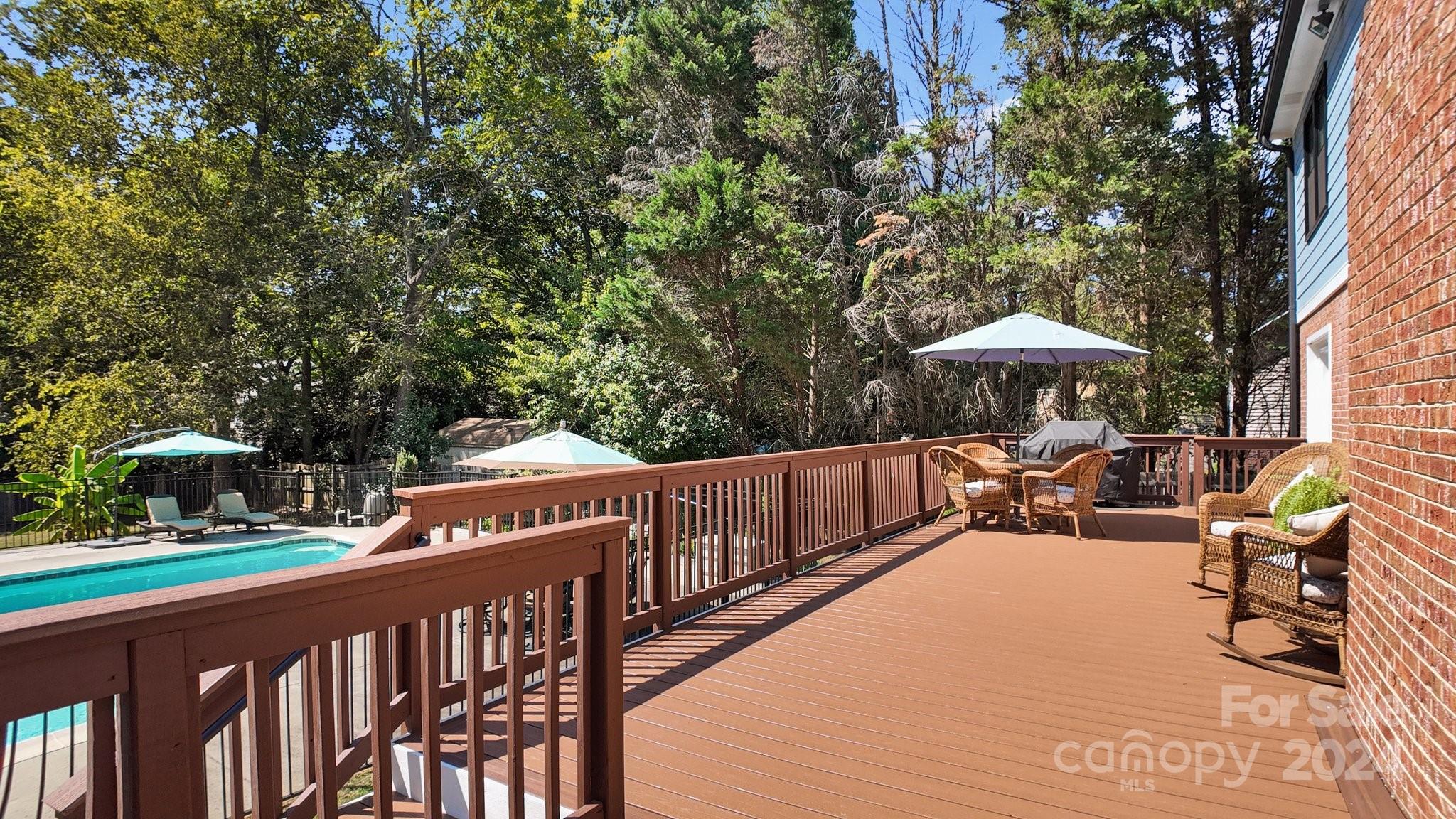 1060 Churchill Road Davidson, NC 28036 - Photo 8 of 41 a view of a patio with a table and chairs under an umbrella with wooden fence