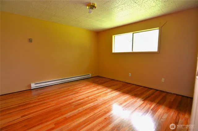 a view of empty room with wooden floor