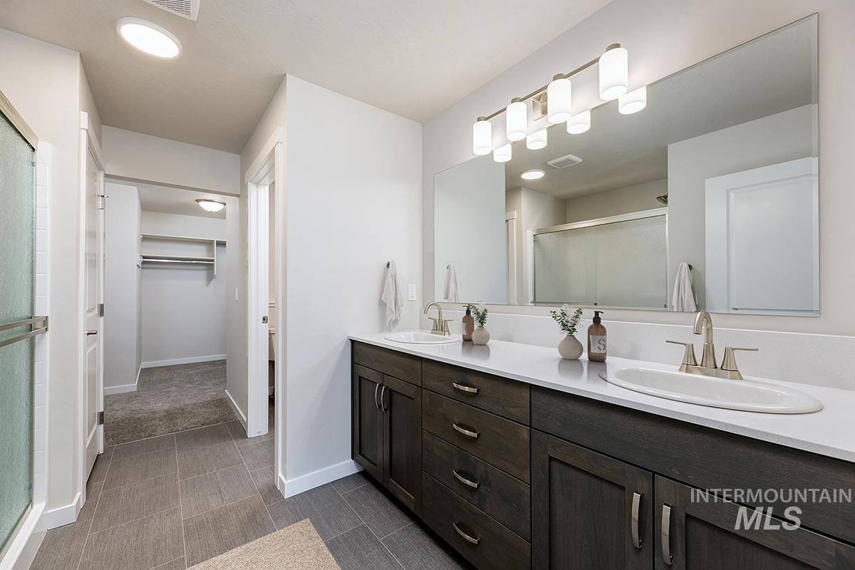 7080 South Gamely Avenue Meridian, ID 83642 - Photo 11 of 30 Bathroom featuring a spacious closet, double vanity, and a stall shower