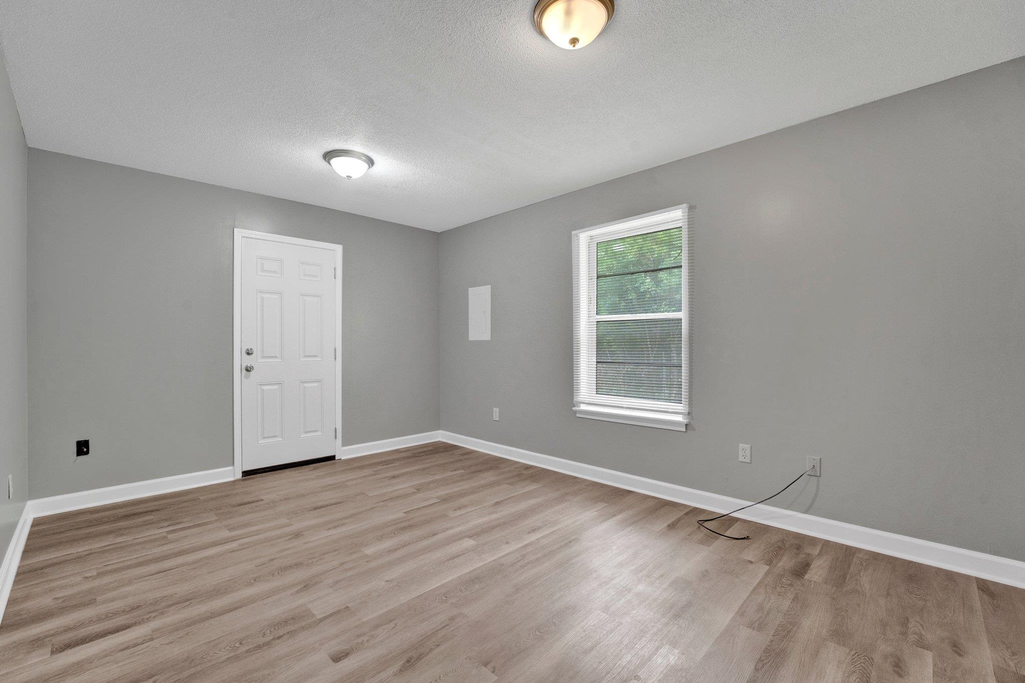 175 Stoneham Road Memphis, TN 38109 - Photo 13 of 25 a view of an empty room with wooden floor and a window