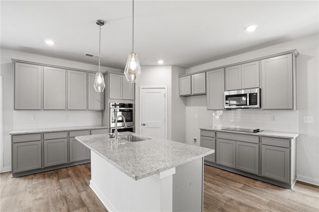 5351 Tolar Road South Fulton, GA 30213 - Photo 6 of 30 a kitchen with stainless steel appliances granite countertop a sink a stove and a wooden floors