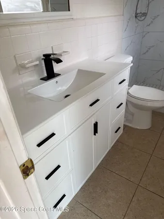 a spacious bathroom with a granite countertop sink a toilet and bathtub